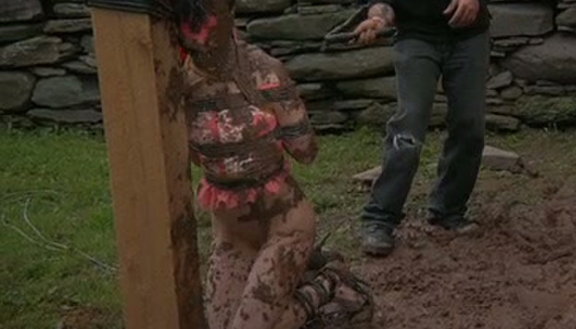 Messy brunette is tied up and covered with mud porn pics