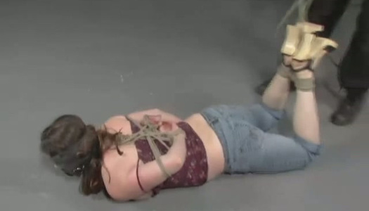 Hogtied blonde lies on her belly on the dirty floor in her slavemask porn pics